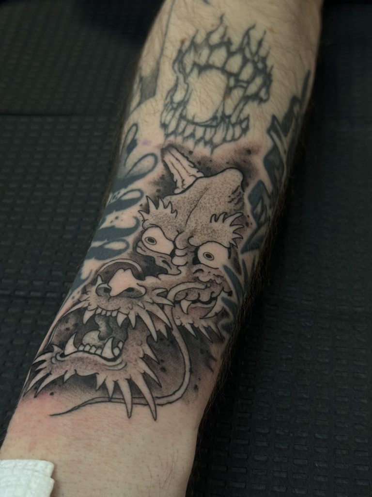 black and grey dragon face tattoo wrist gap filler